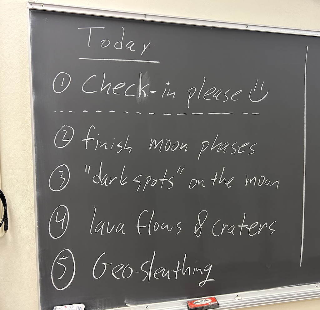A chalk board with a class schedule written on it.